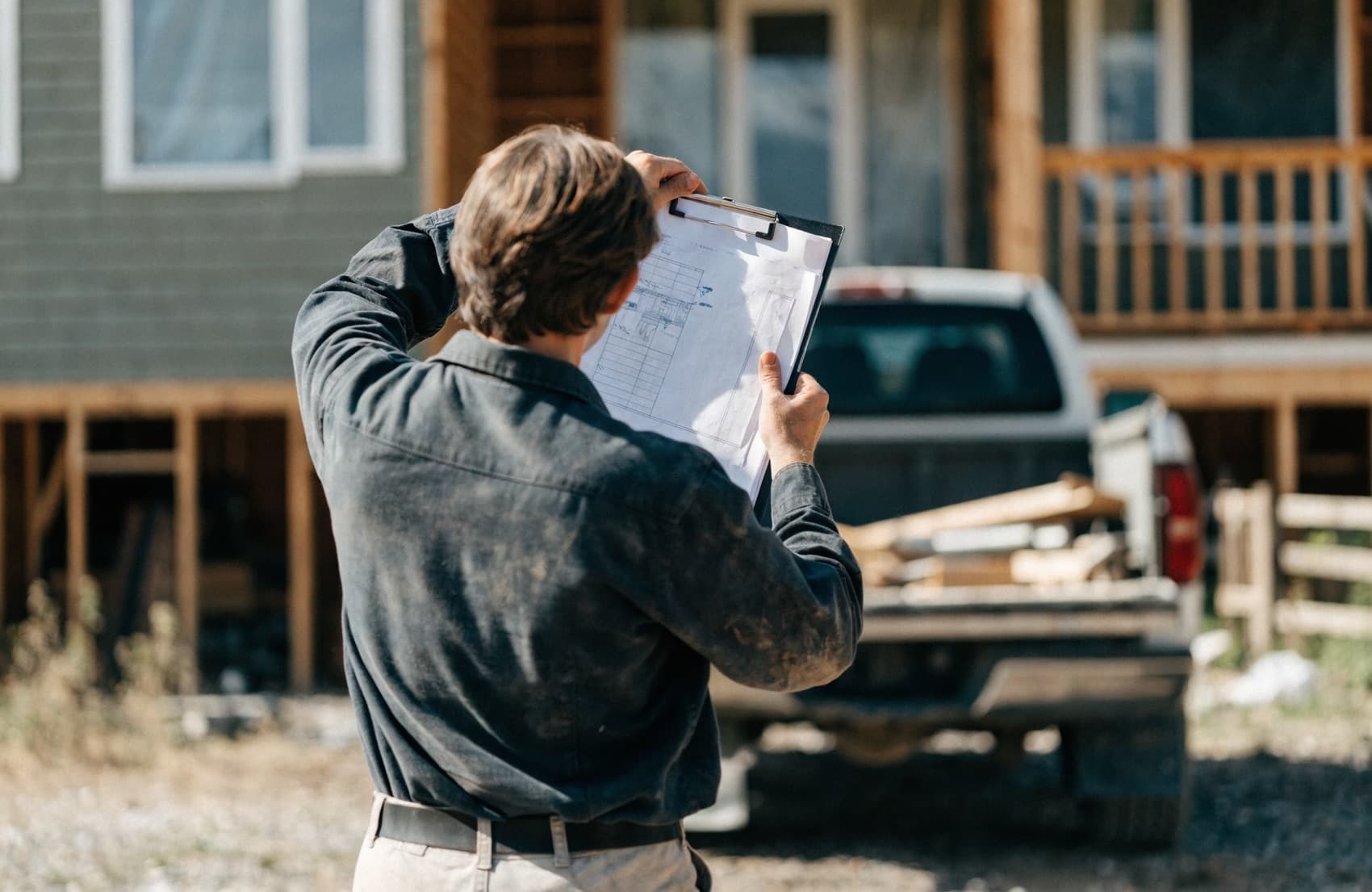 A contractor reviewing booked jobs on a phone outside a job site